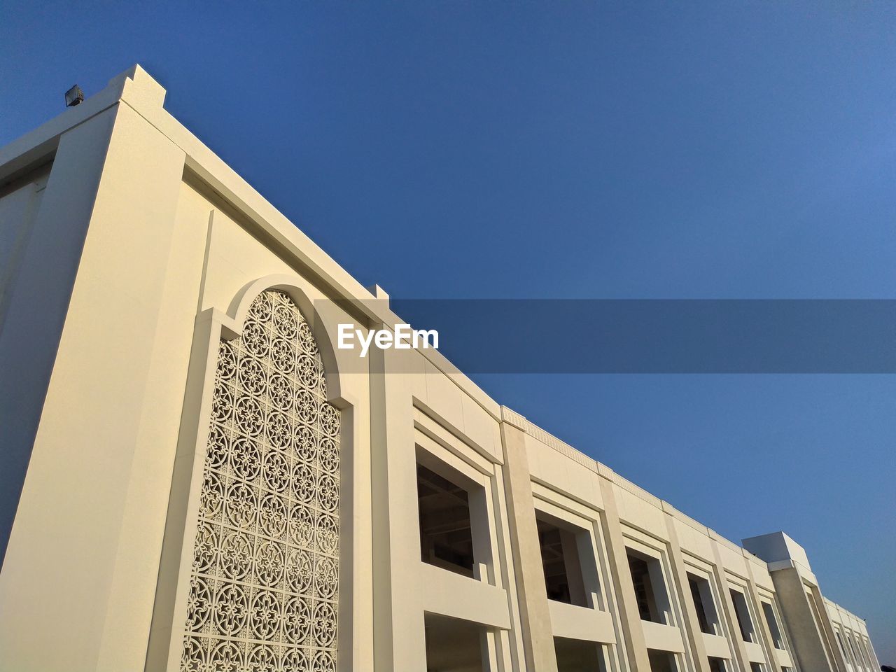 Low angle view of building against clear blue sky