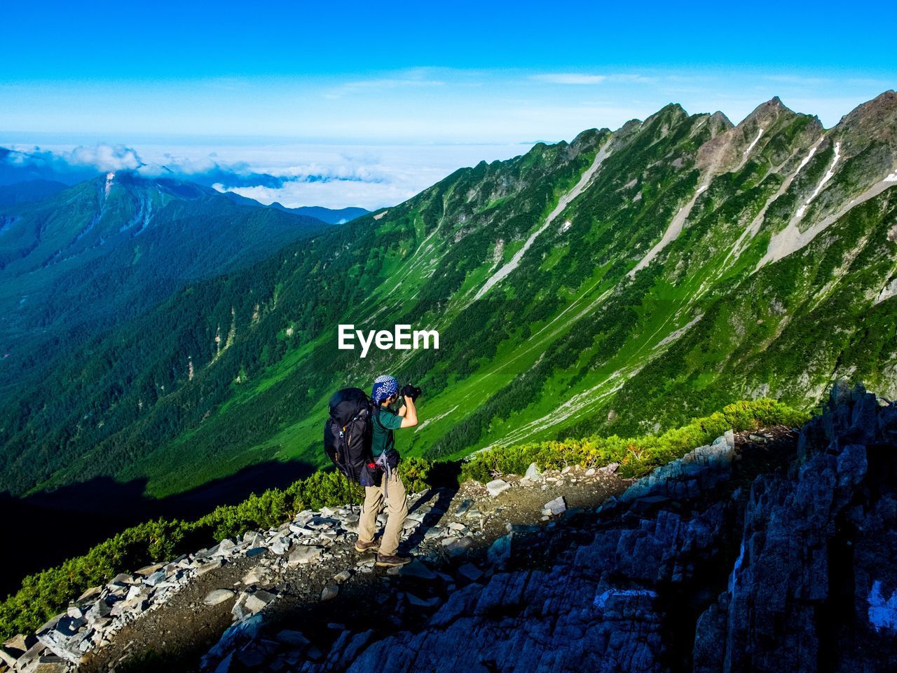 MAN ON MOUNTAINS AGAINST SKY