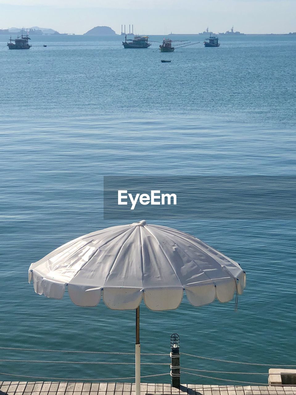View of umbrella on pier against sea