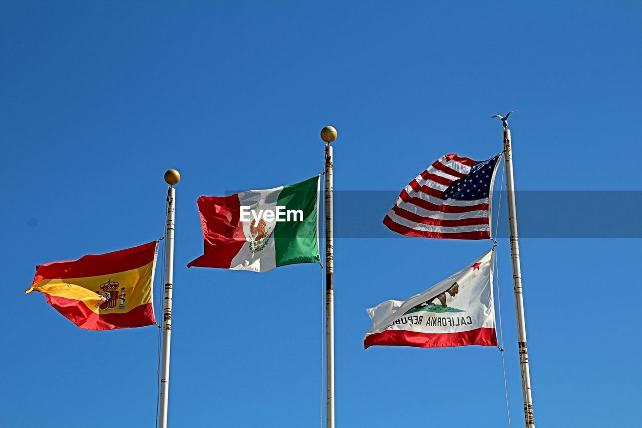 LOW ANGLE VIEW OF FLAG FLAGS AGAINST CLEAR BLUE SKY