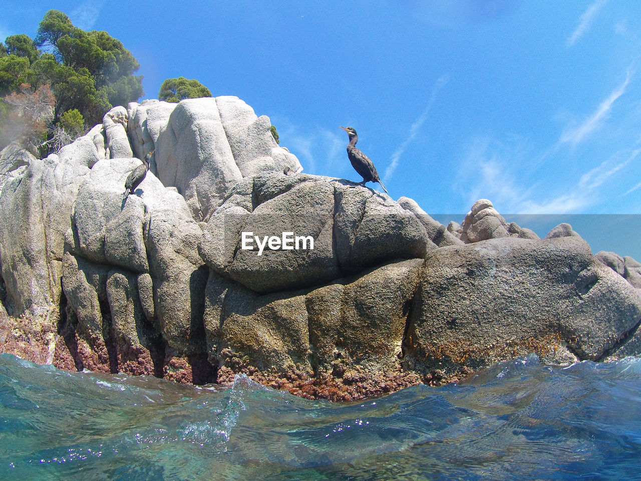 SEA BY ROCKS AGAINST SKY