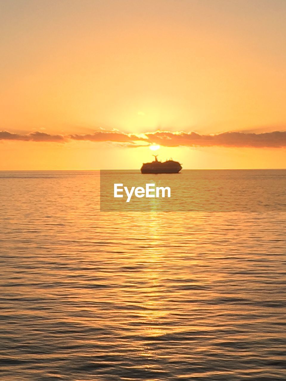 SILHOUETTE BOAT IN SEA AGAINST ORANGE SKY