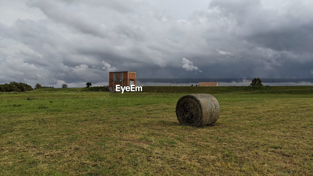 Hay bales on field against sky