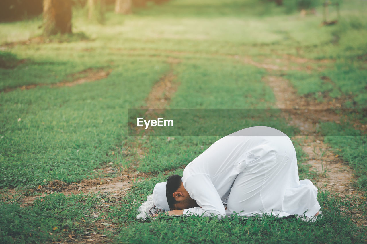 Religious muslim man praying  outdoor at quiet nature  environment sun beams.