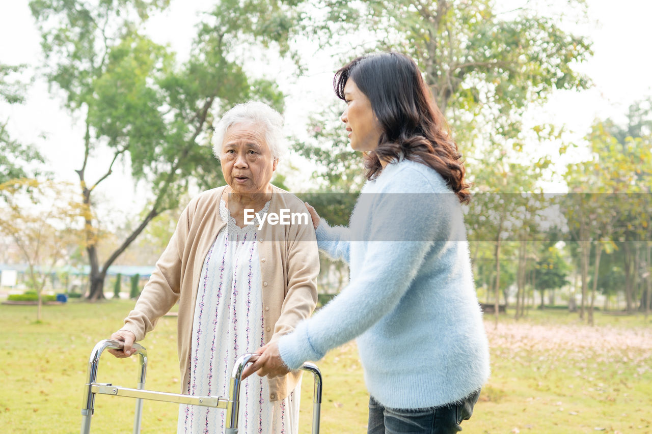 Happy friends standing on ground against blurred background