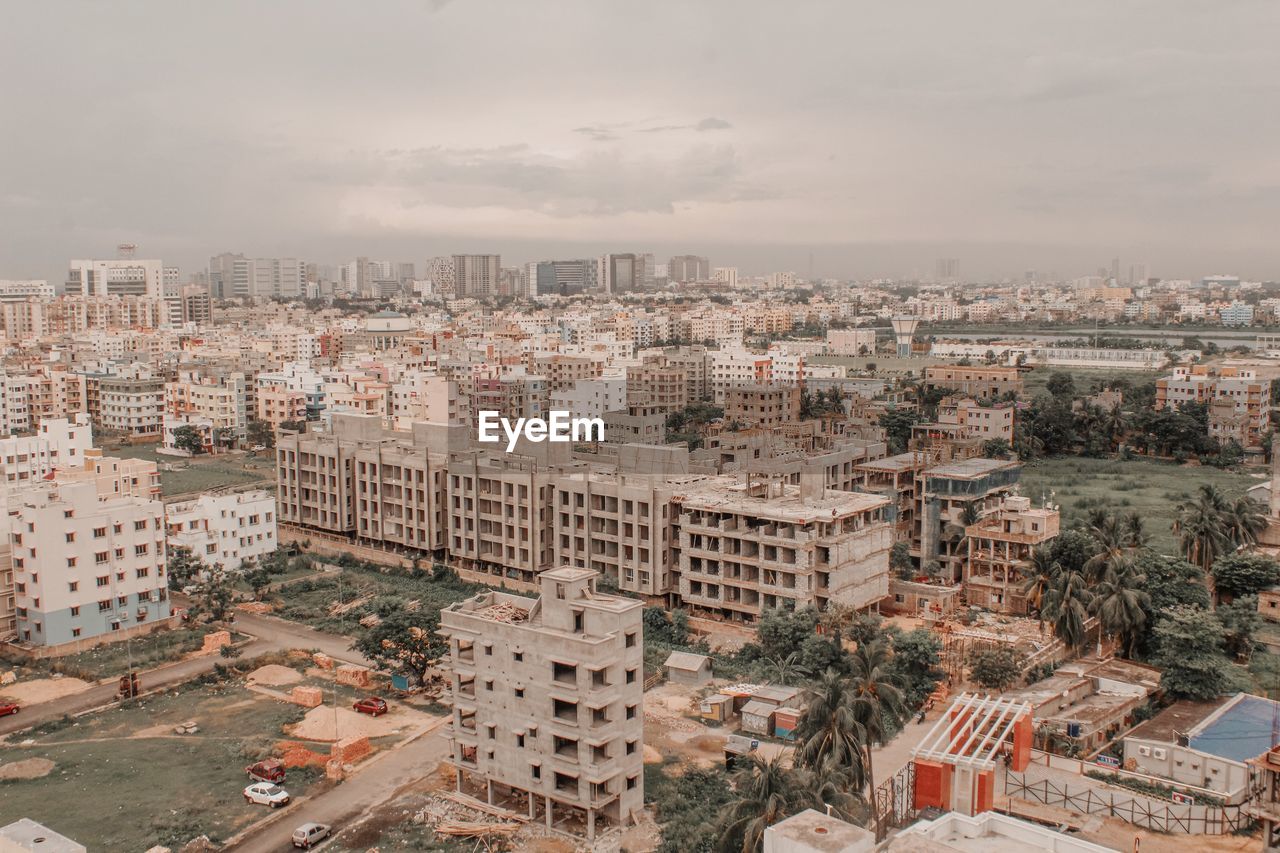 HIGH ANGLE VIEW OF BUILDINGS AGAINST SKY IN CITY