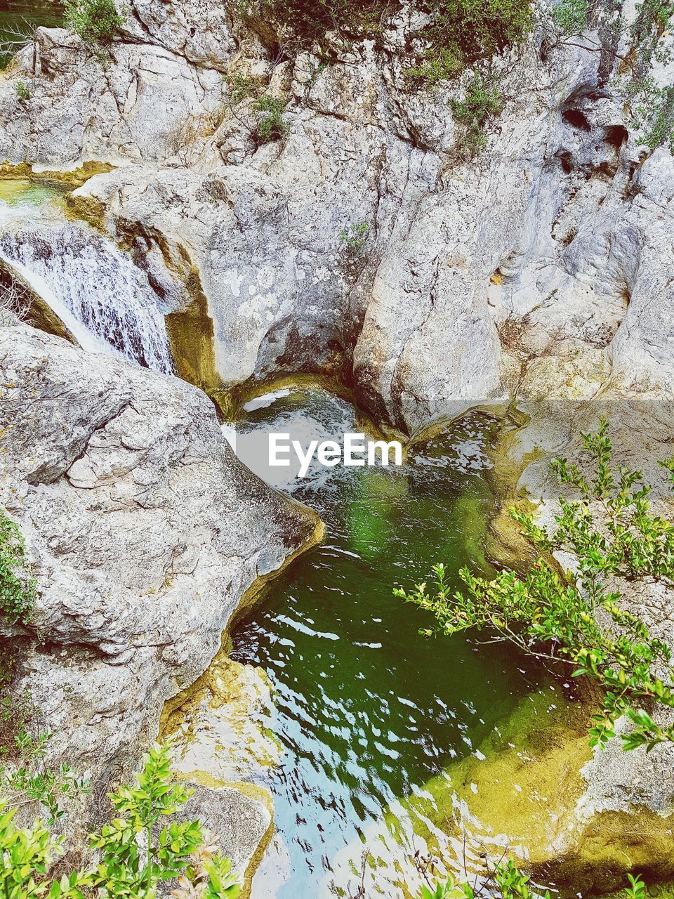 HIGH ANGLE VIEW OF WATER FLOWING THROUGH ROCKS