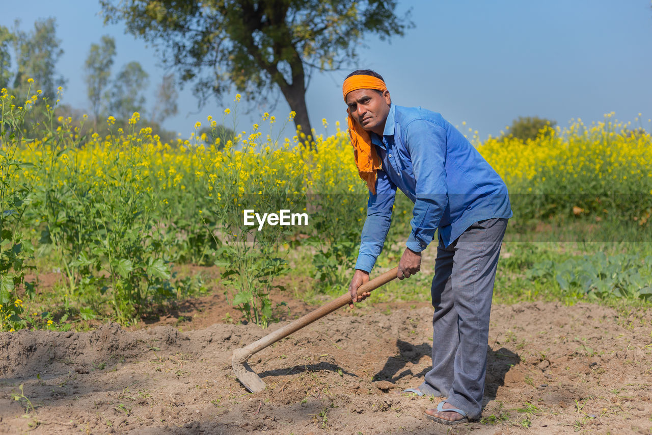 Full length portrait of man working on field