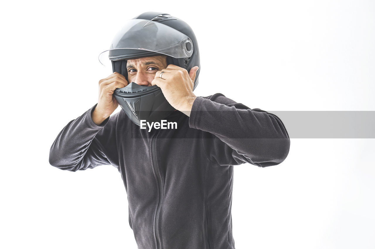 Man with a motorcycle helmet giving a thumbs up gesture. isolated on white studio wall.