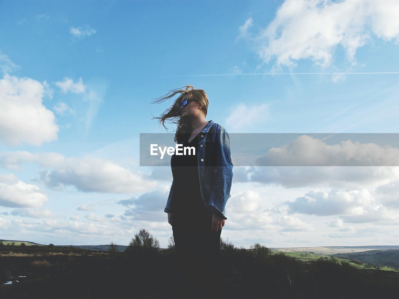 Teenage girl standing against sky