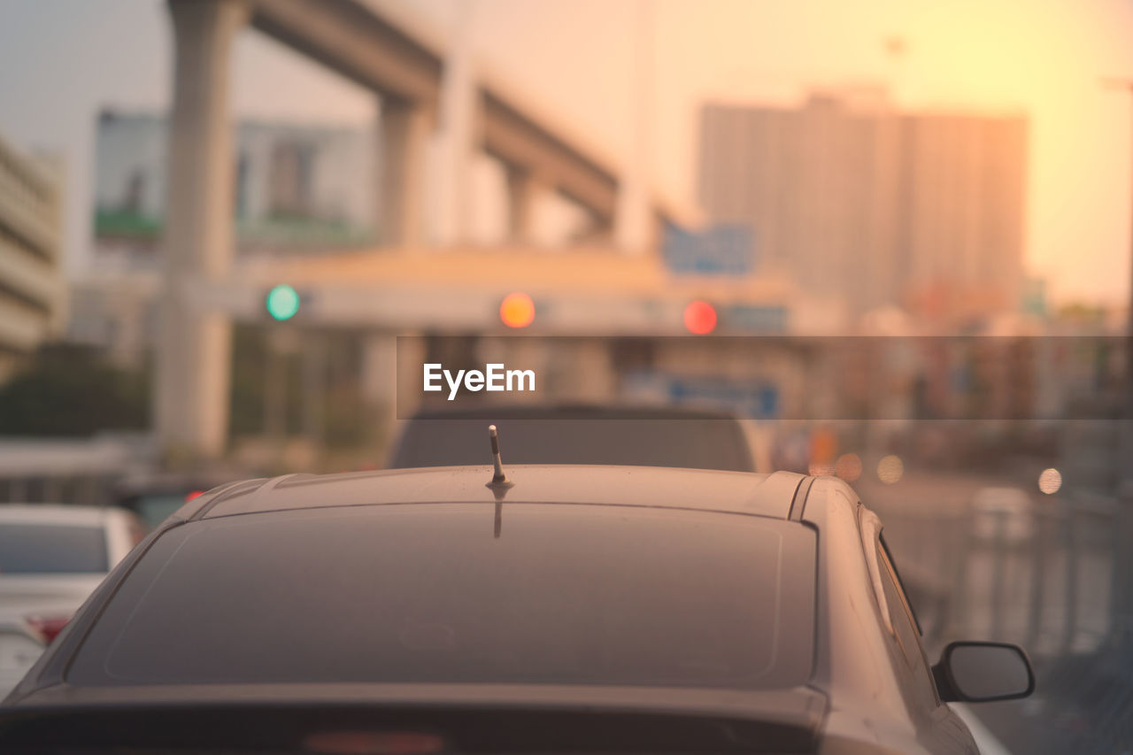 Close-up of car on road at sunset