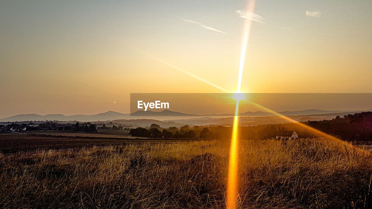 SCENIC VIEW OF FIELD AGAINST SKY AT SUNSET