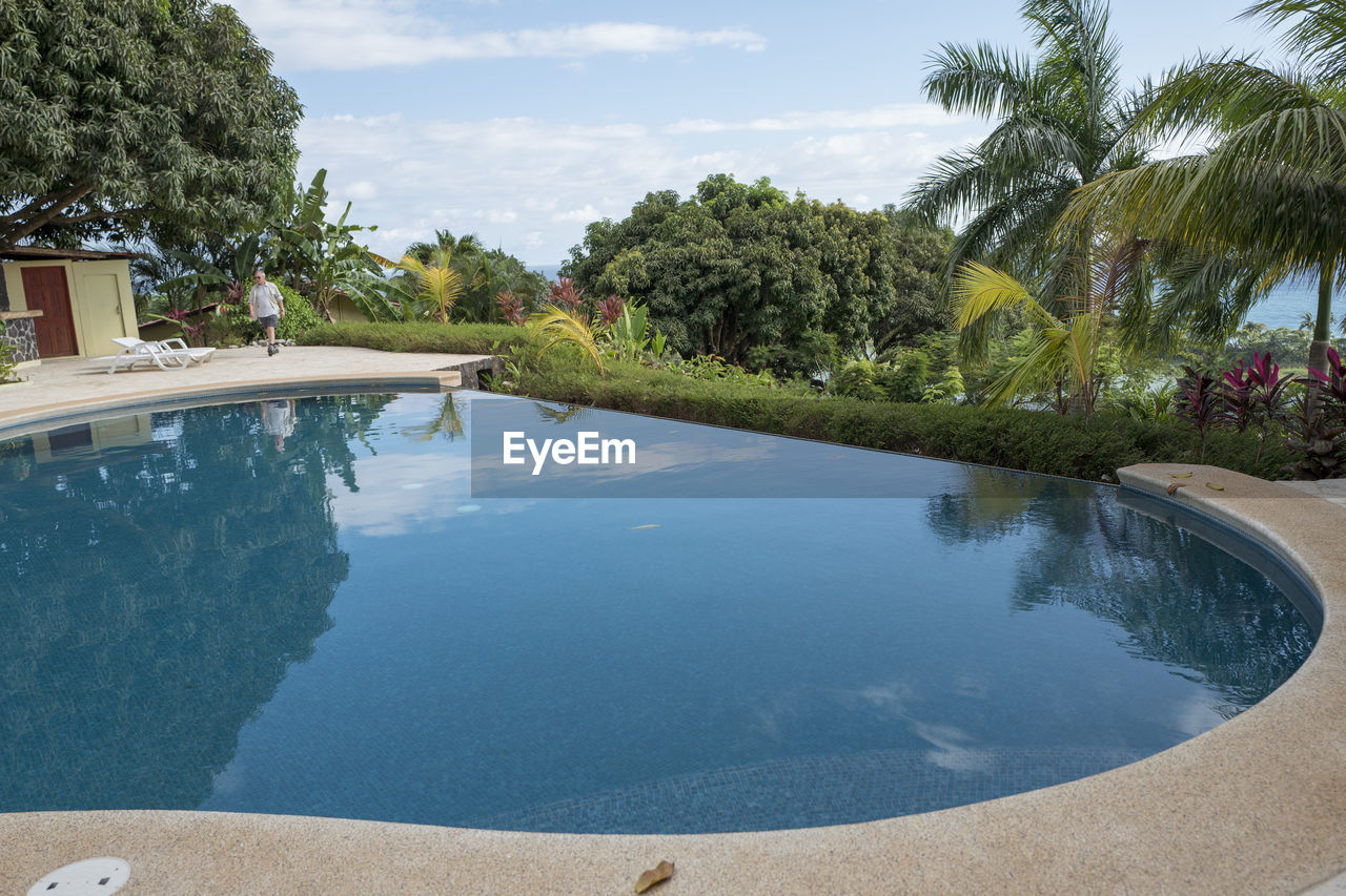 SWIMMING POOL AND TREES AGAINST SKY