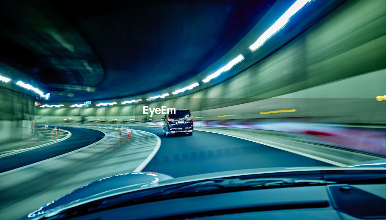 Illuminated tunnel seen through car windshield