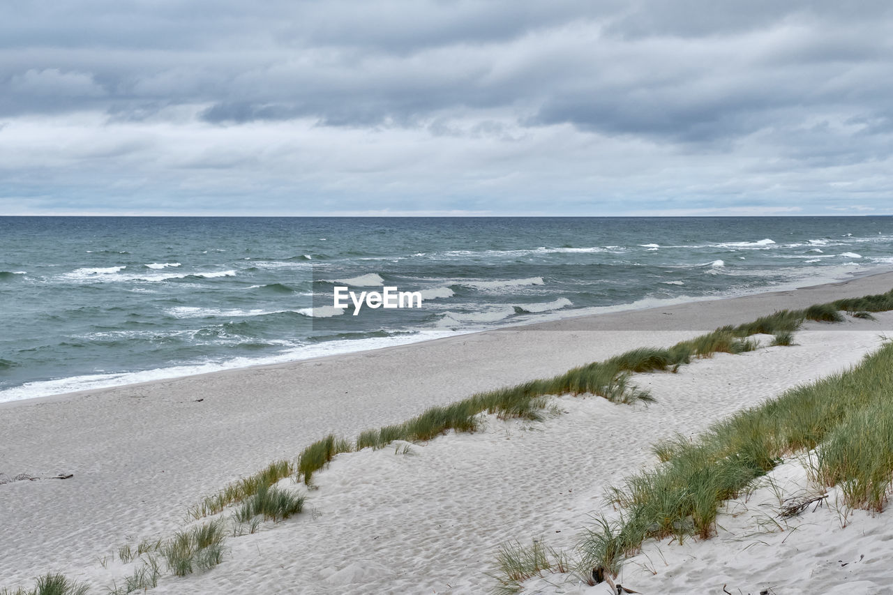 SCENIC VIEW OF SEA SHORE AGAINST SKY