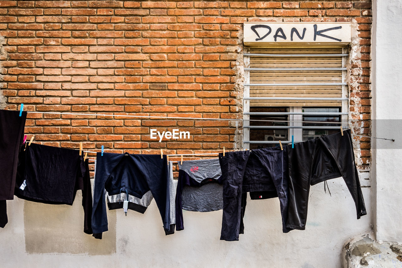 CLOTHES HANGING ON BRICK WALL