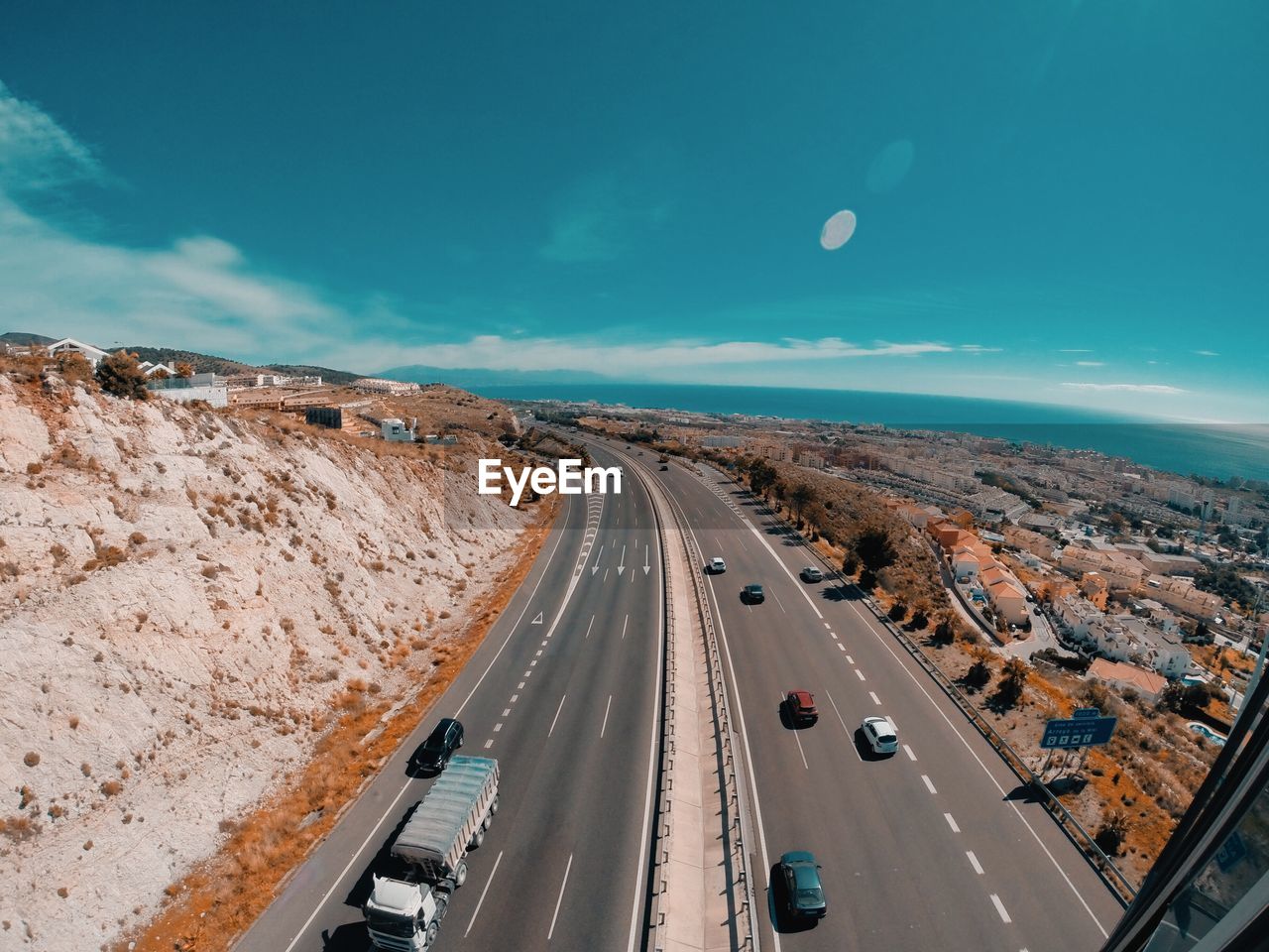 Aerial view of highway by sea against sky