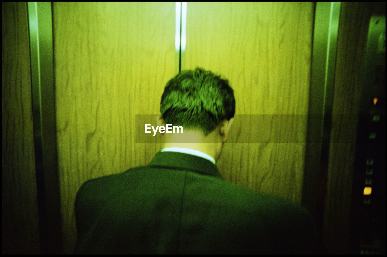 Rear view of businessman in elevator