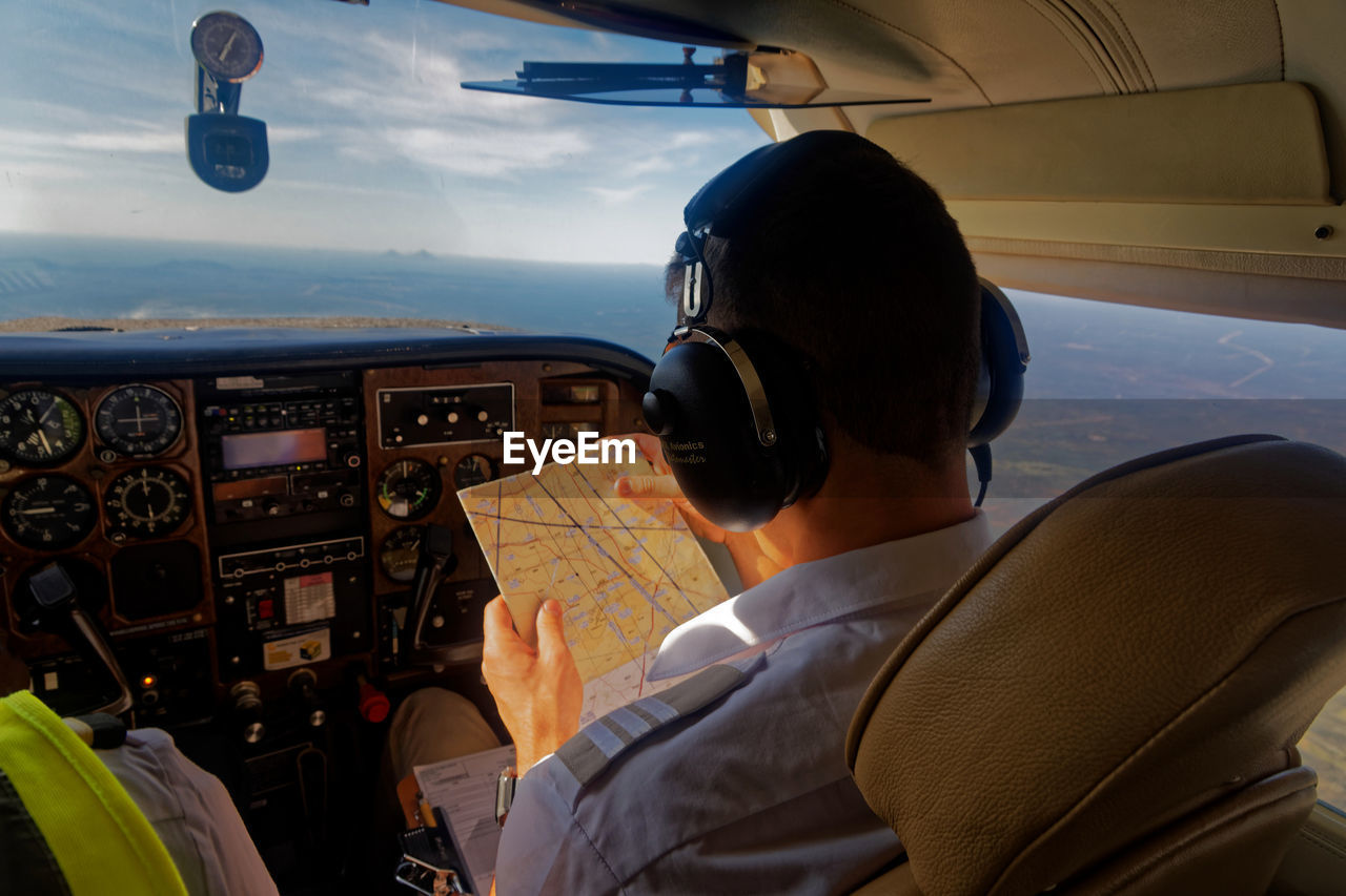 PORTRAIT OF MAN WITH AIRPLANE FLYING IN MID-AIR