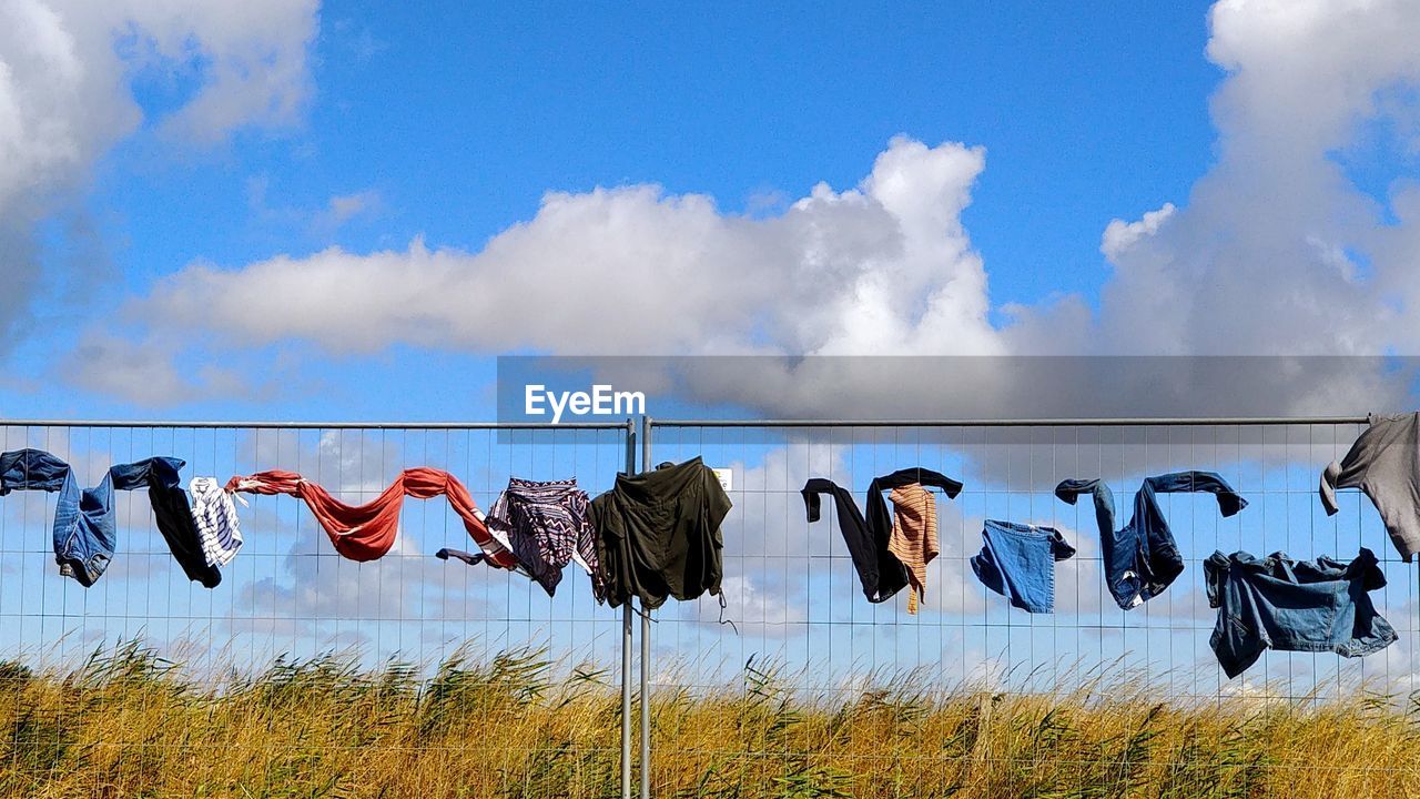 CLOTHES DRYING HANGING AGAINST SKY