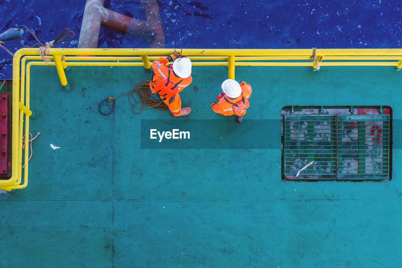 Offshore workers preparing sling and rigging for anchor handling at construction  barge at oil field