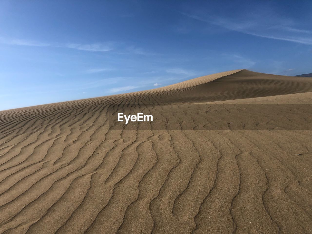 Sand dunes in desert against sky