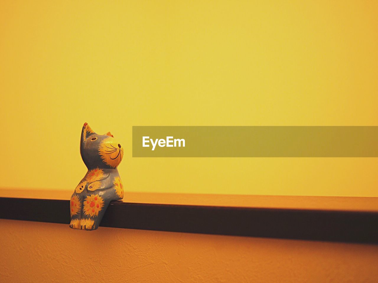 Close-up of toy on table against yellow background