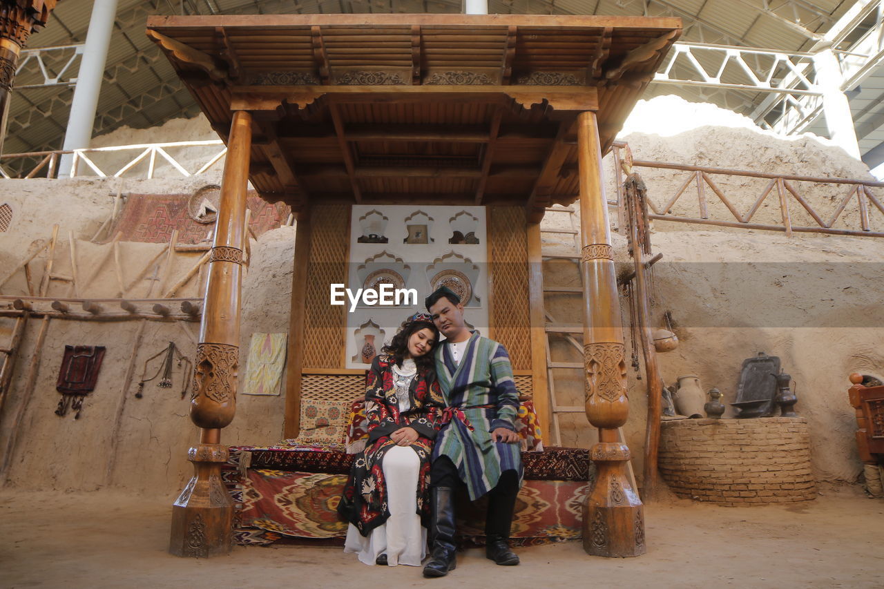 Portrait of smiling couple sitting by temple