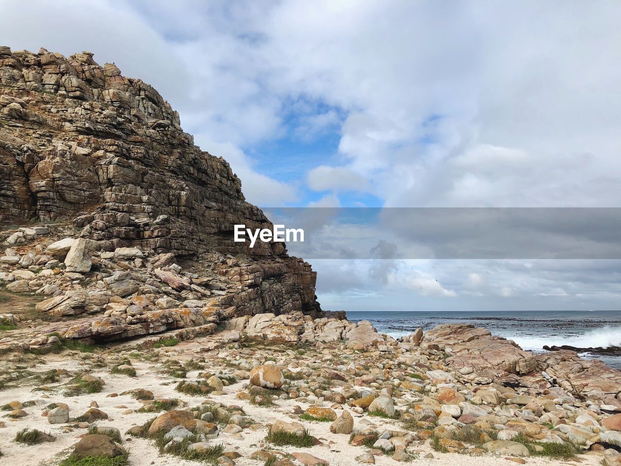 Rock formation on beach against sky