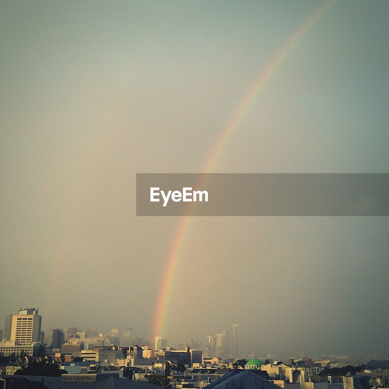 Cityscape against sky with rainbow