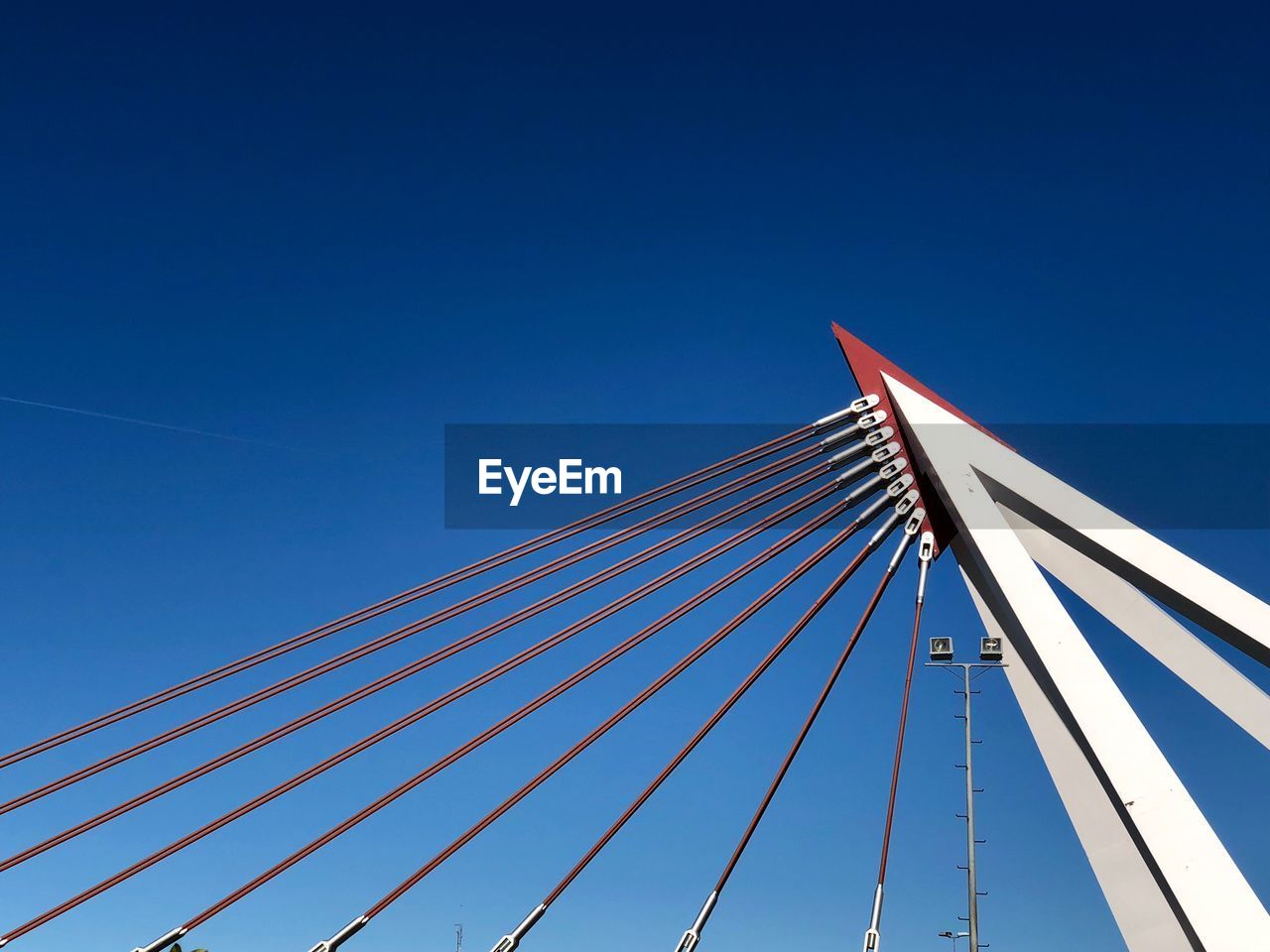 Low angle view of suspension bridge against clear blue sky