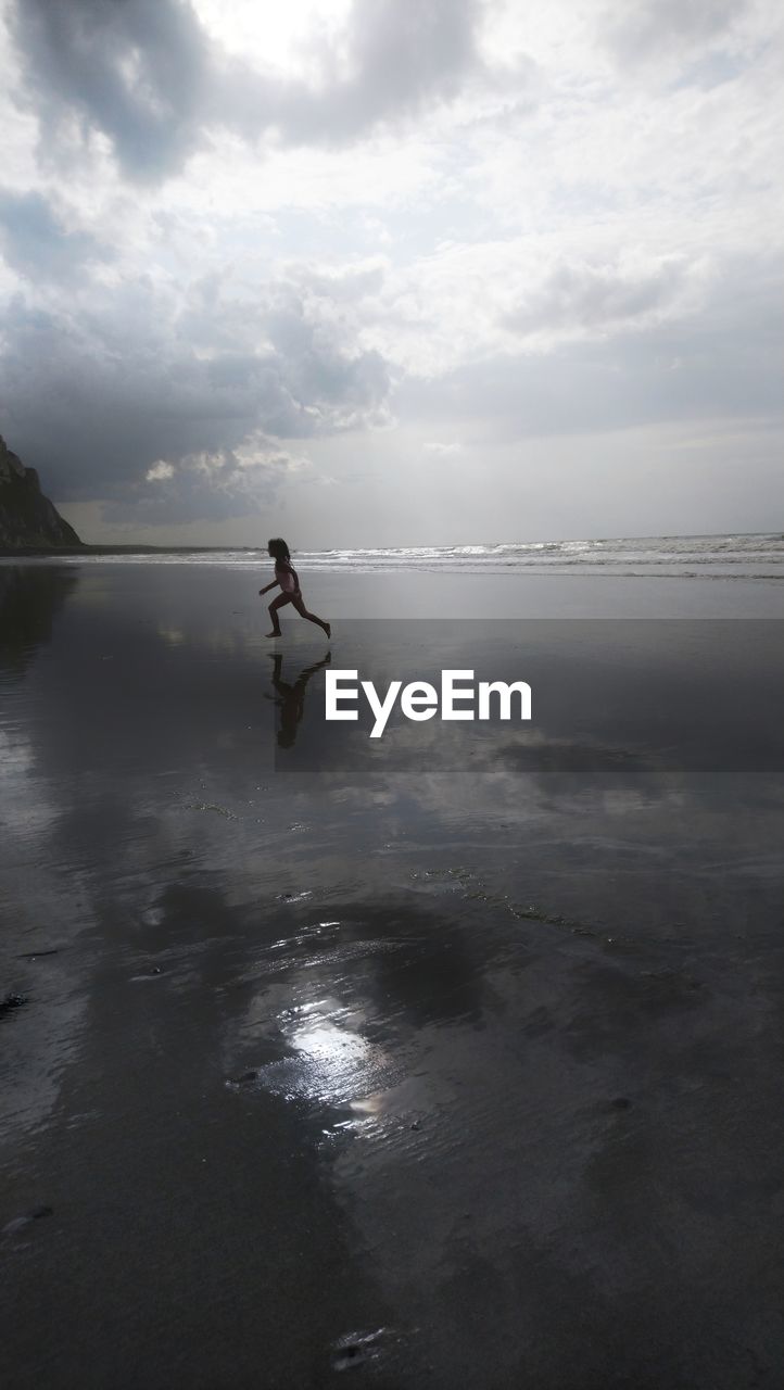 SIDE VIEW OF MAN ON BEACH