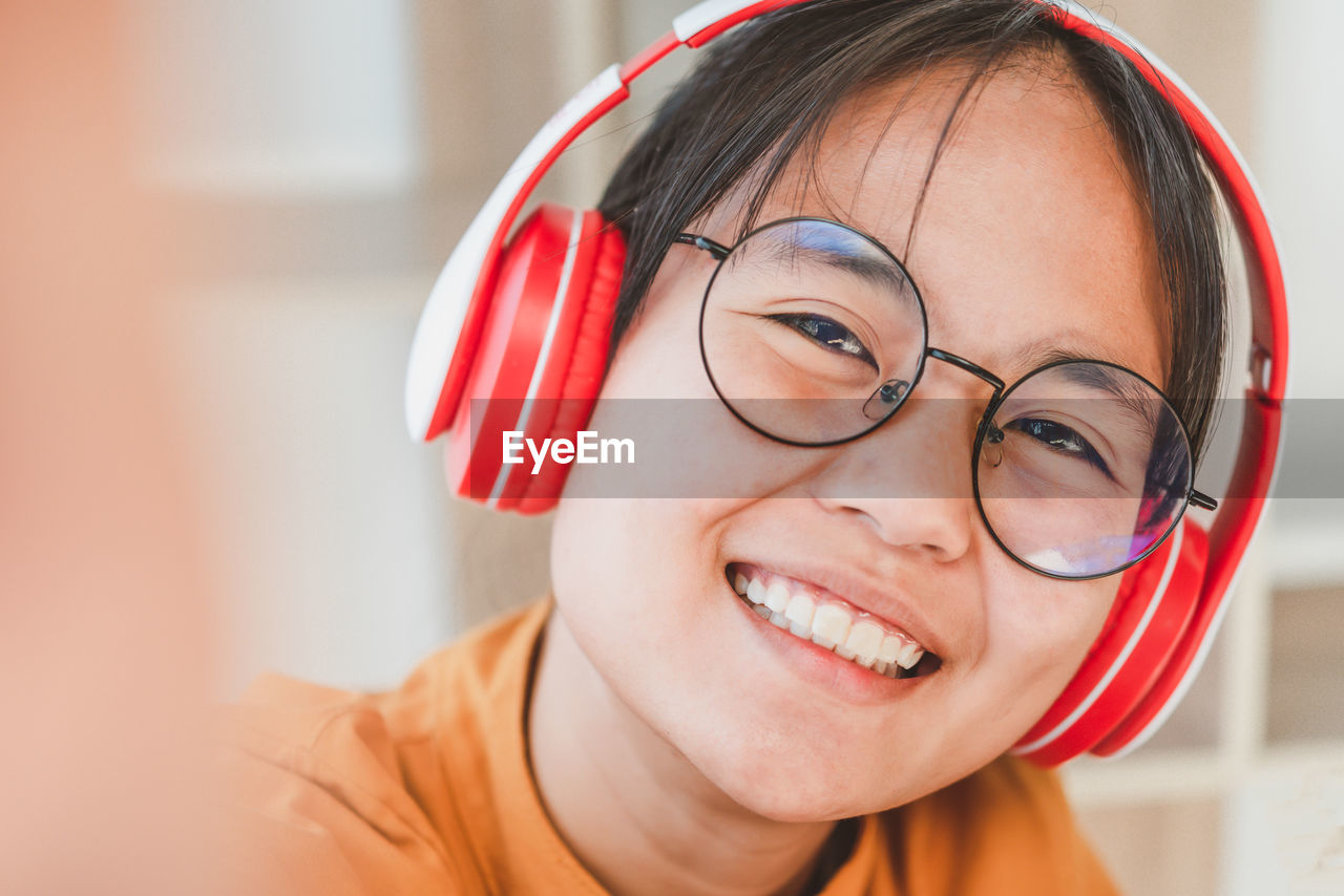 Close-up portrait of smiling girl with headphones