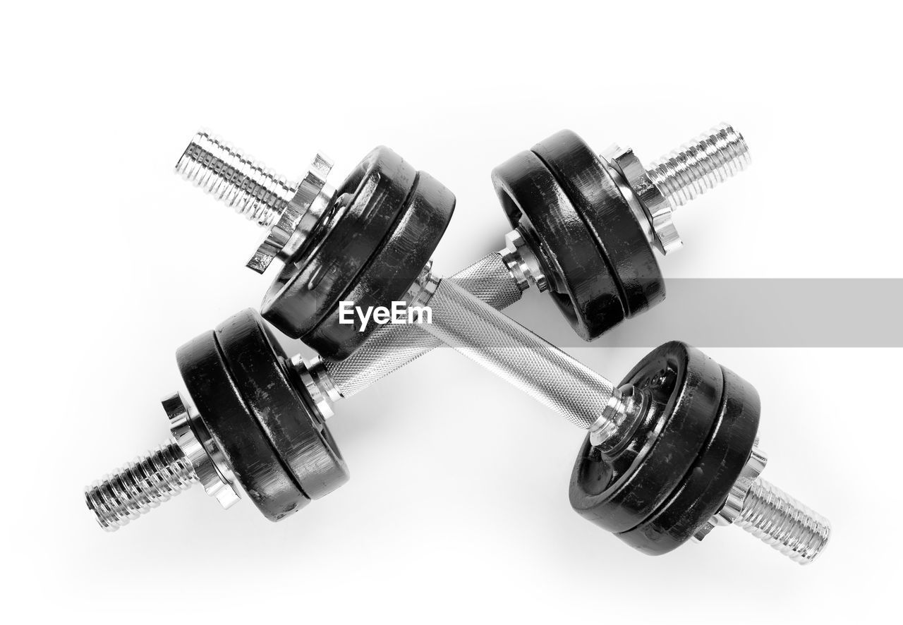 Close-up of dumbbells over white background