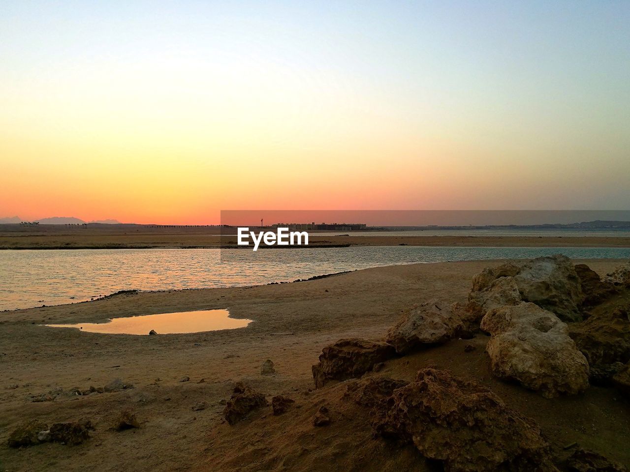 SCENIC VIEW OF BEACH AGAINST SKY DURING SUNSET