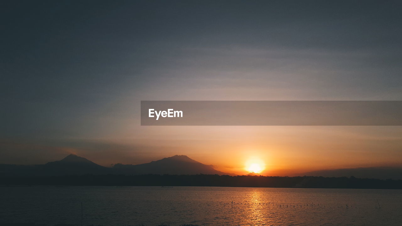 Scenic view of silhouette mountains against sky during sunset