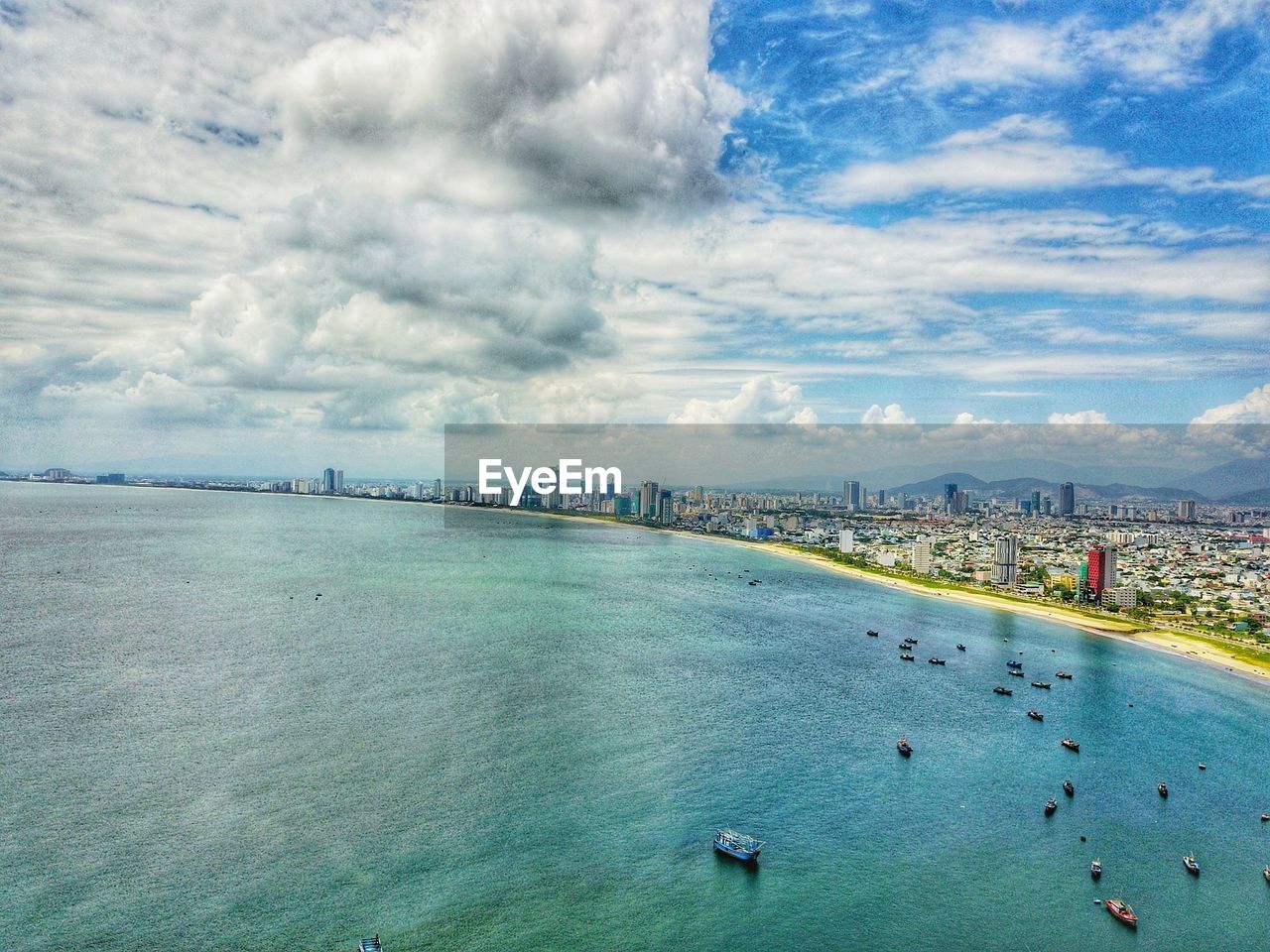 High angle view of boats in sea against cloudy sky