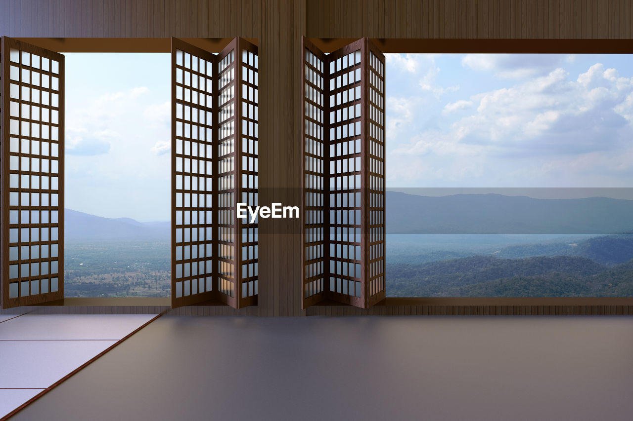 Built structure by glass window against sky