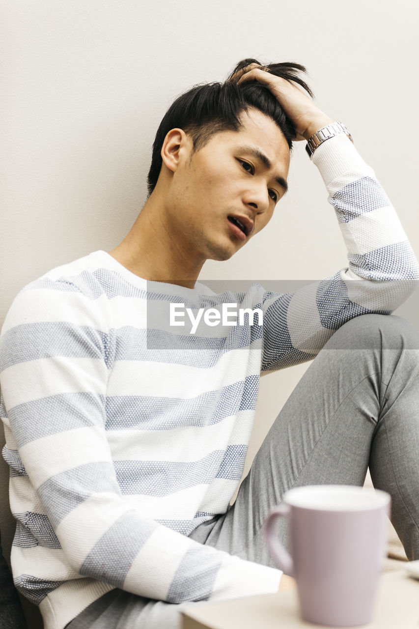 Tensed young man sitting at home