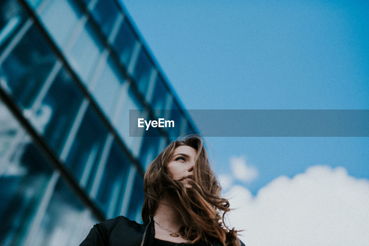 Low angle view of woman standing against sky