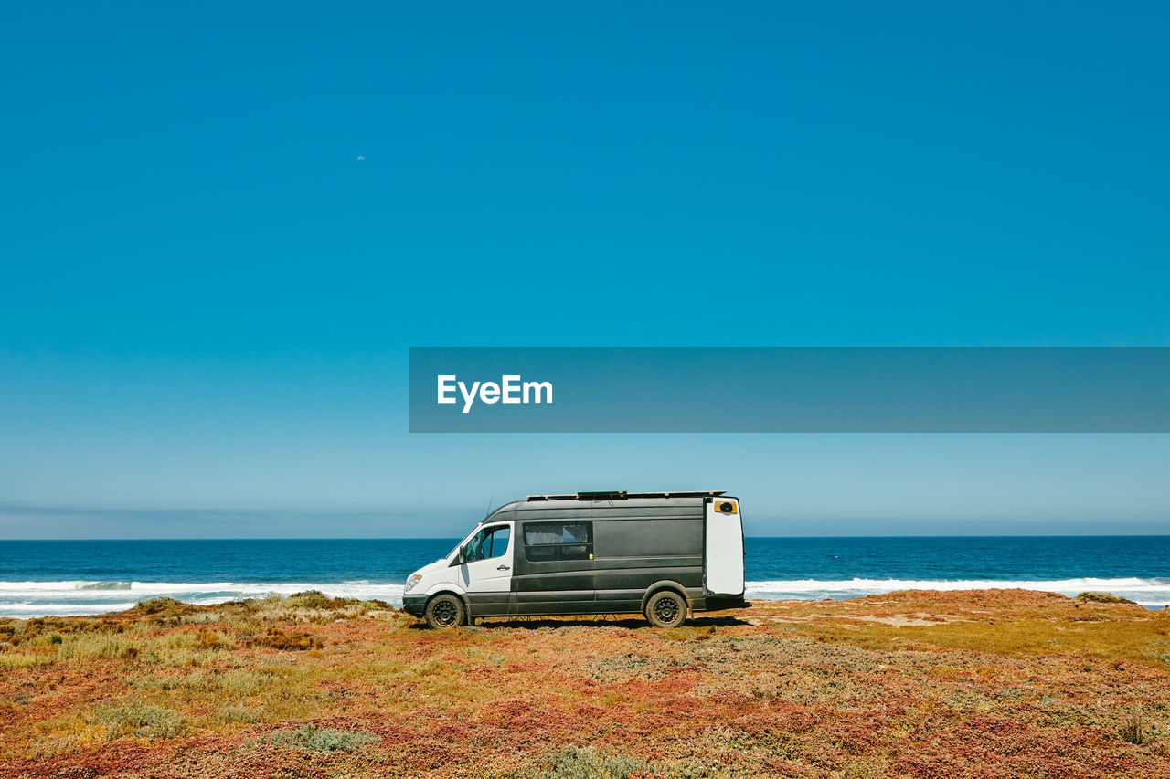 Camper van parked on ocean cliff beach during summer in baja, mexico.