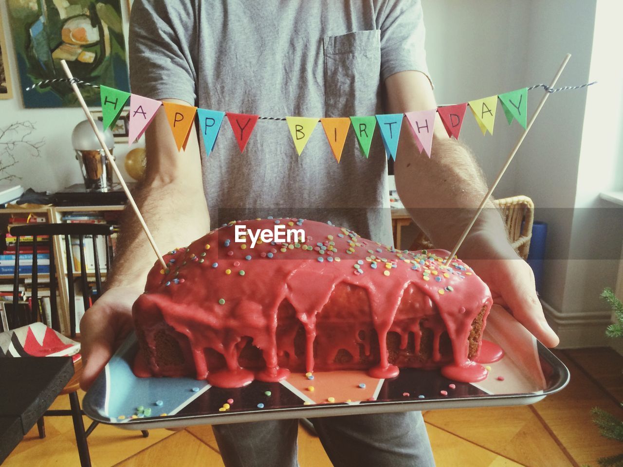 Midsection of man holding birthday cake