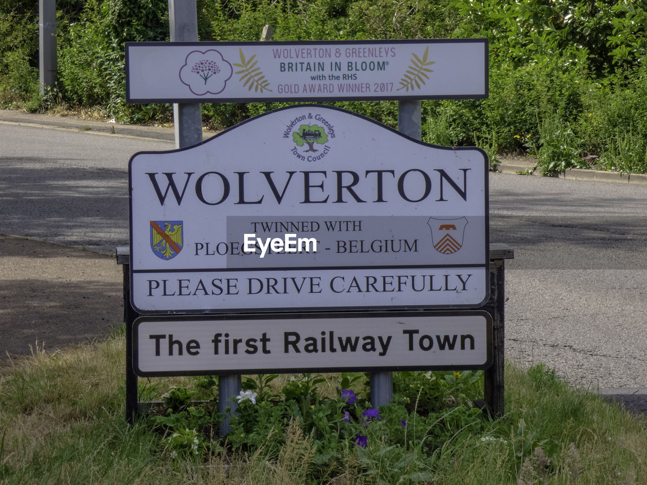 INFORMATION SIGN ON ROAD BY GRASS