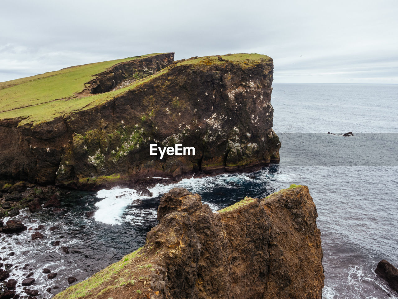 Rock formations by sea against sky