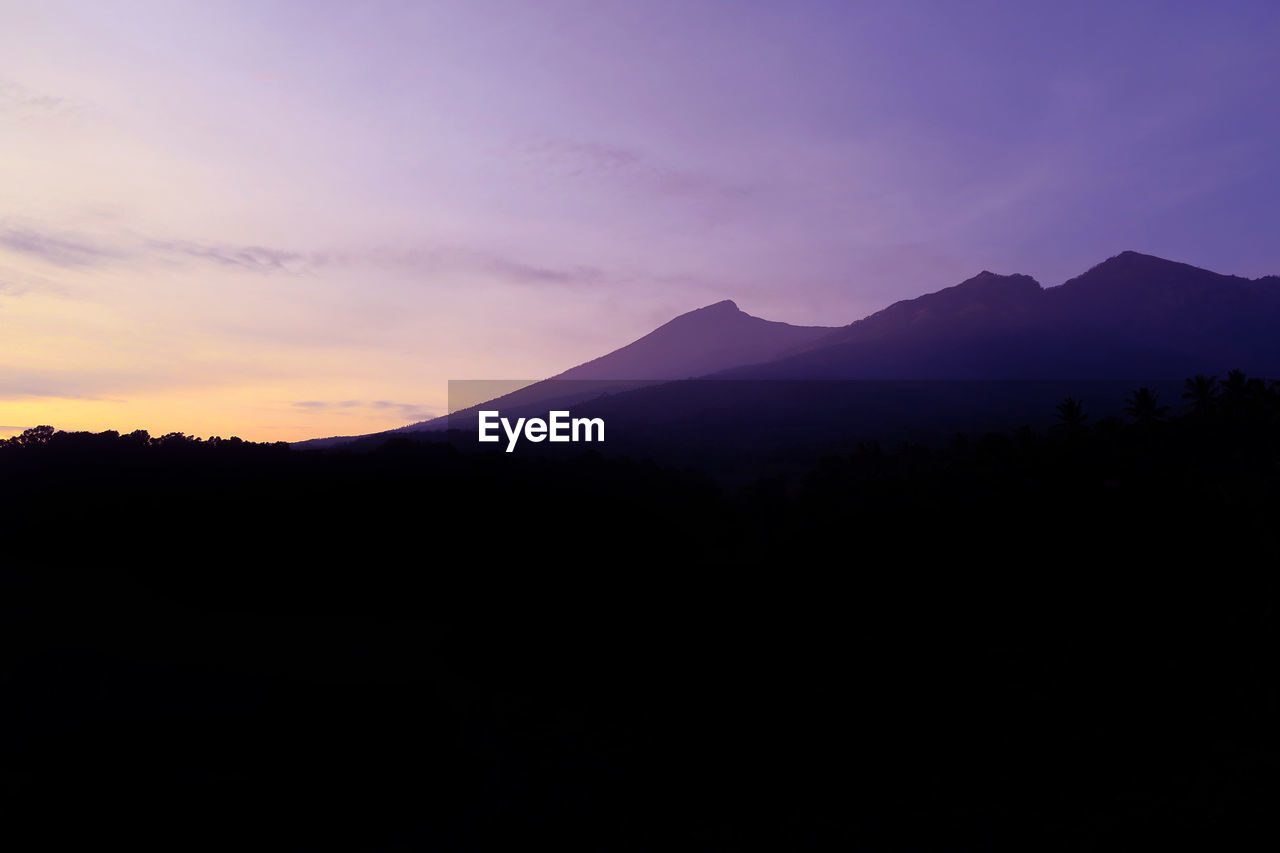 SCENIC VIEW OF DRAMATIC SKY OVER SILHOUETTE MOUNTAINS