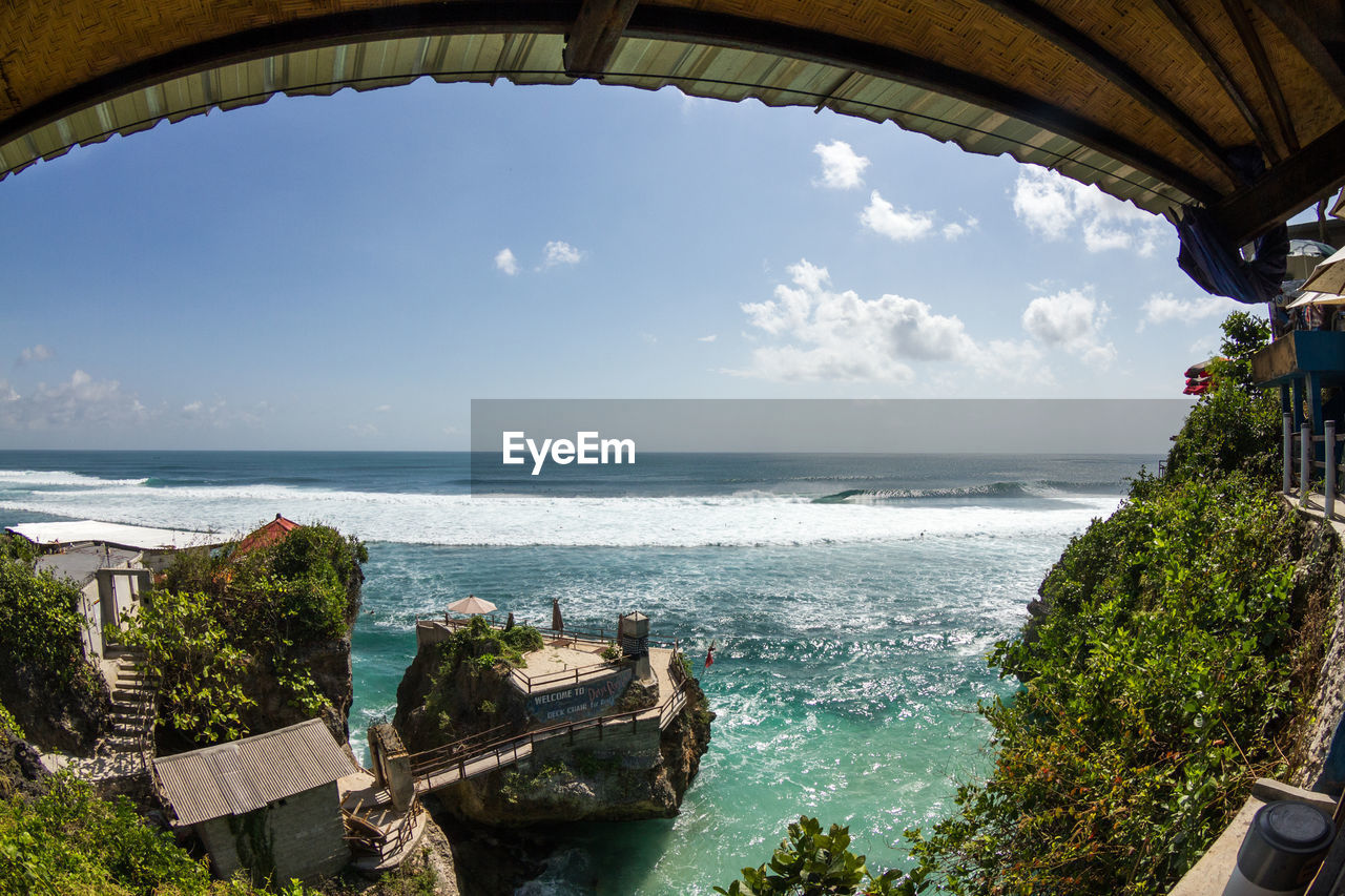 View of concrete structure with trees on cliff at sea