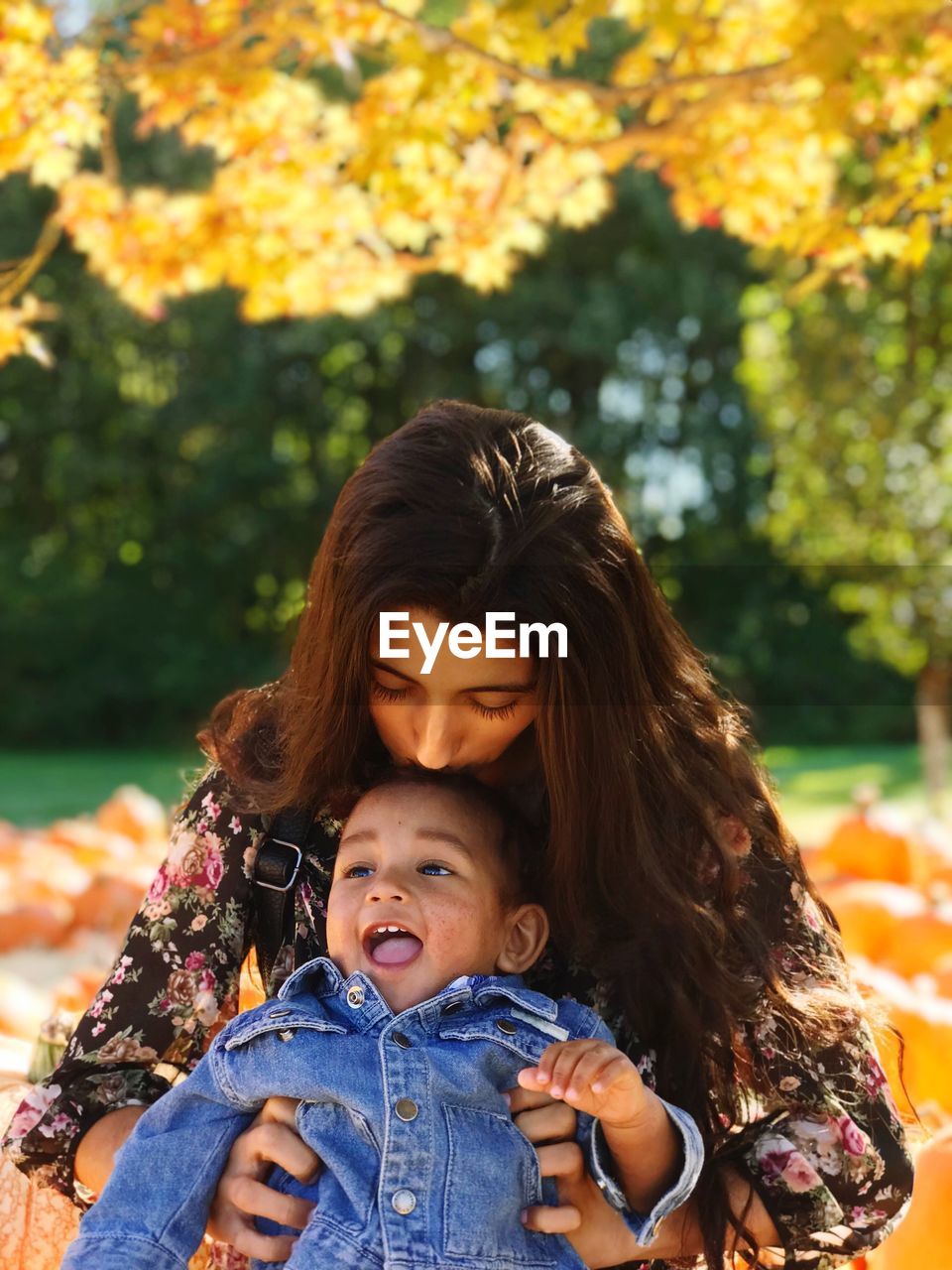 PORTRAIT OF HAPPY MOTHER AND SON AT PARK