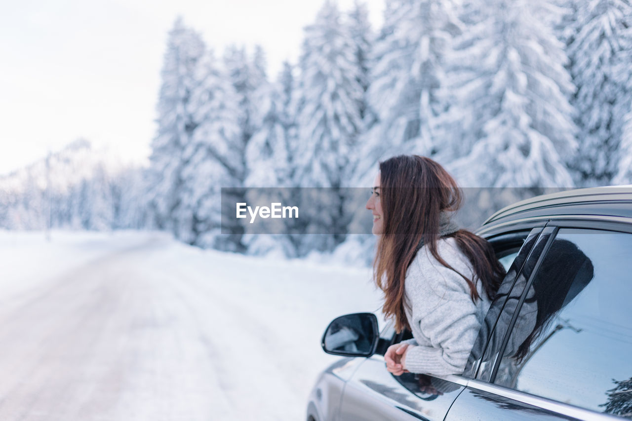 Woman having fun while on a road trip during winter.