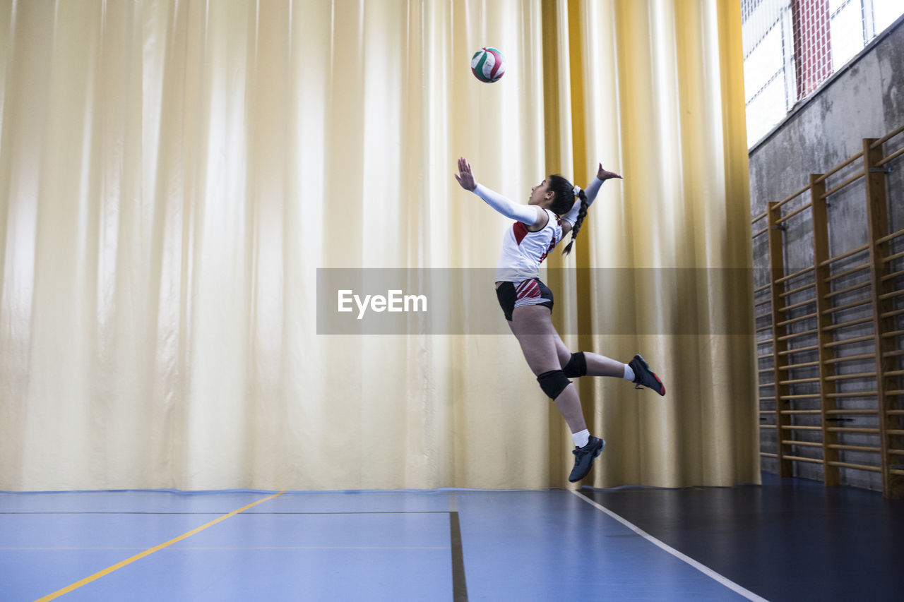 Professional female volleyball player in action serving ball