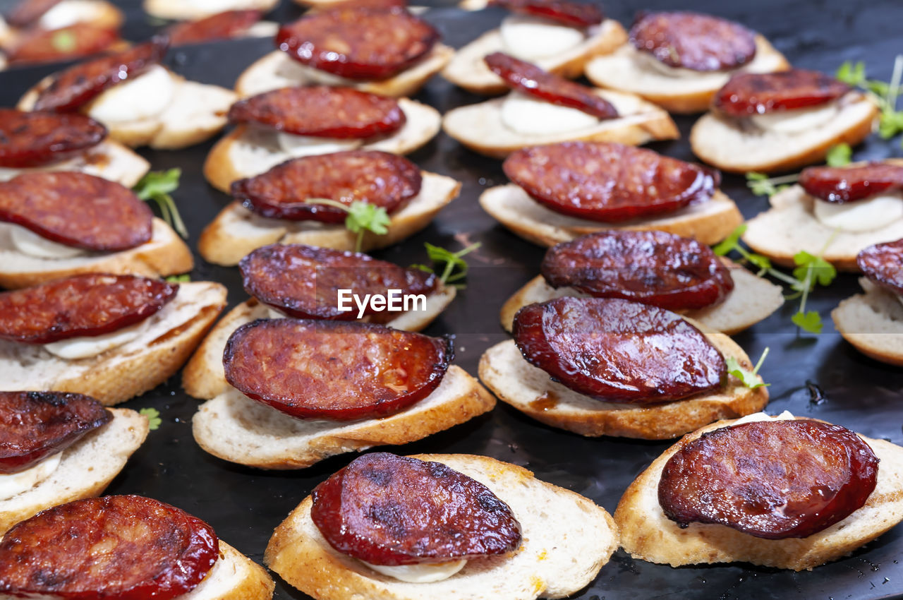 High angle view of party finger food on table. chorizo on sliced baguette.